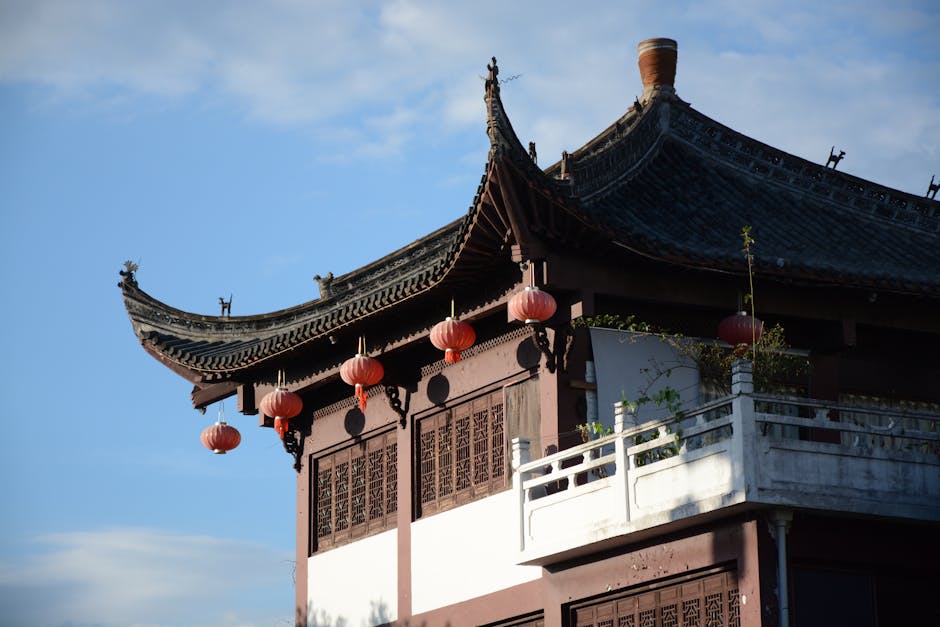 A classic Chinese building featuring traditional architecture and red lanterns under a clear blue sky.