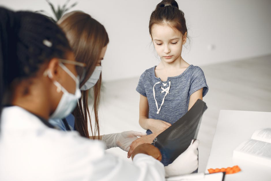 Young girl undergoing a medical checkup with doctors reviewing her x-ray