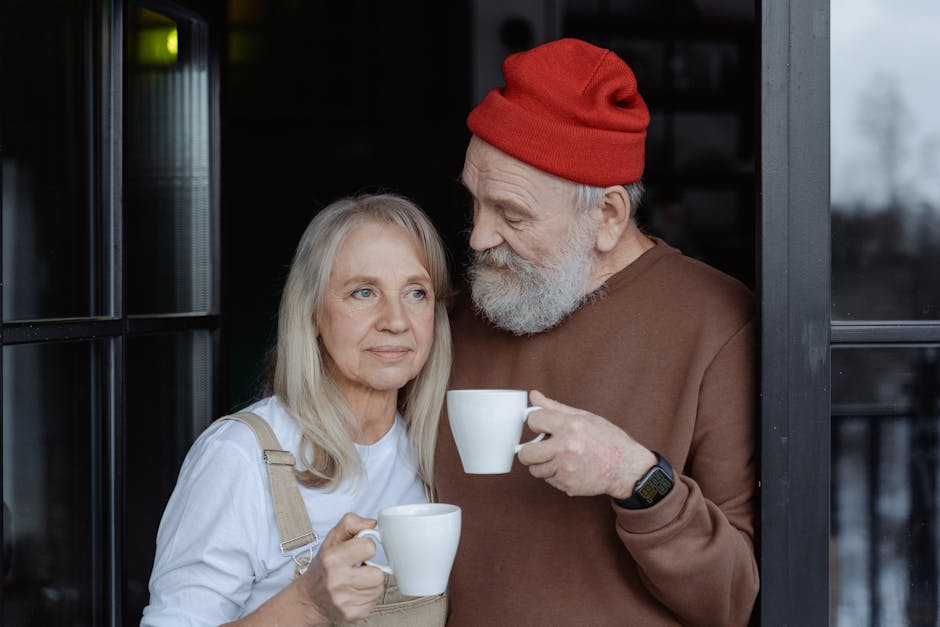 Senior couple sharing a moment with coffee cups, enjoying a peaceful time at home.
