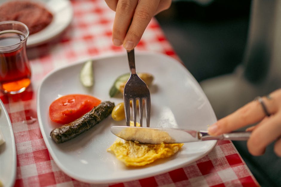 A close-up of a traditional breakfast plate with assorted foods on a checkered tablecloth.