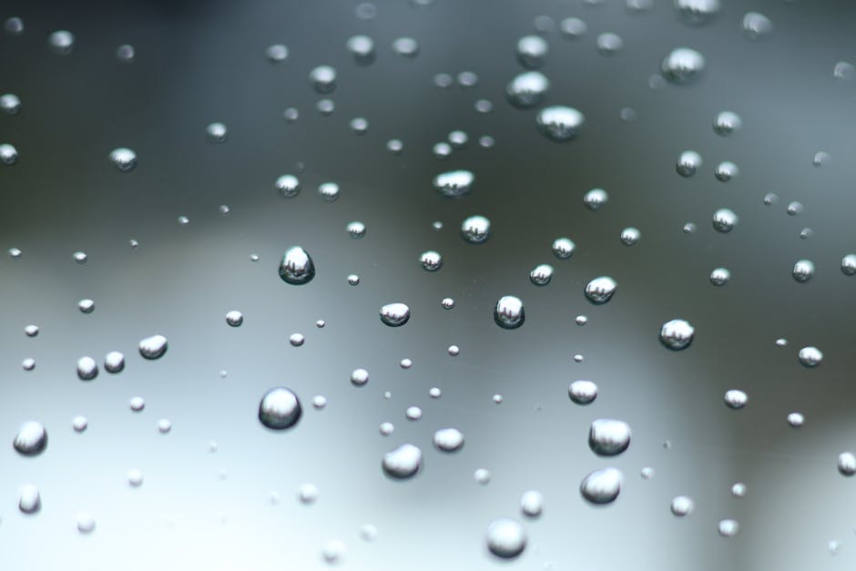 Close-up of water droplets on glass creating a blurred, artistic abstract effect.