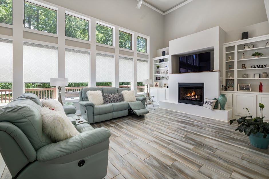 Bright and spacious living room with fireplace, large windows, and stylish furniture.