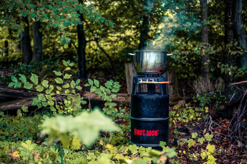 A wok cooking setup in a lush forest, showcasing an off-the-grid culinary experience.