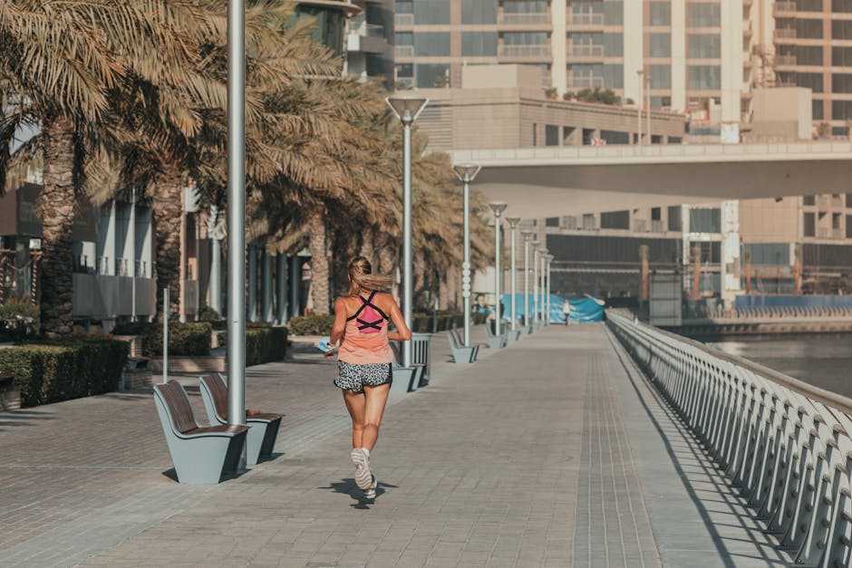 A woman jogging along the waterfront promenade in Dubai Marina, capturing urban fitness and leisure.