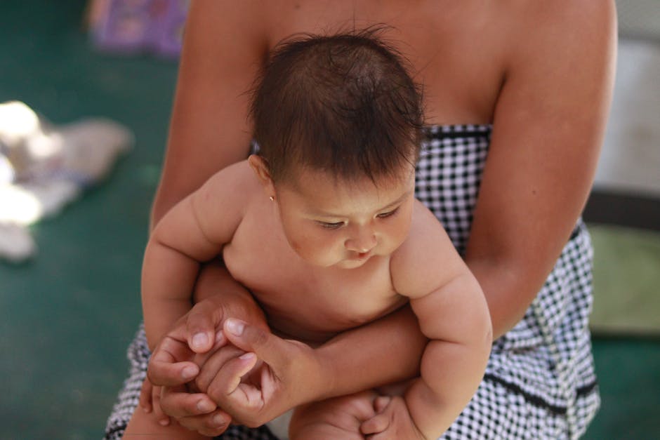 A mother lovingly holds her baby indoors, capturing a tender moment. Shot in Lima, Perú.