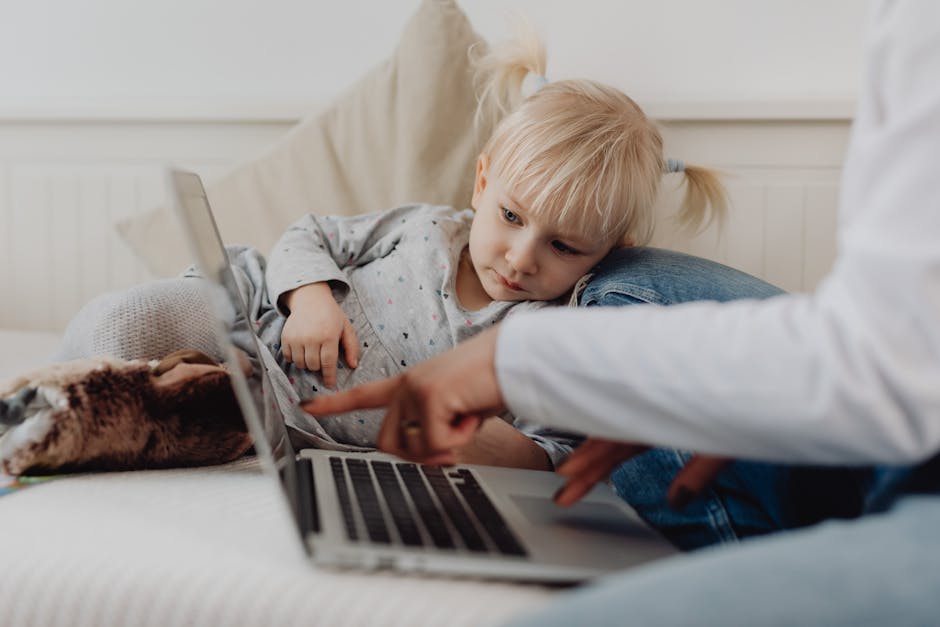 A young girl learning with a laptop while sitting comfortably indoors.