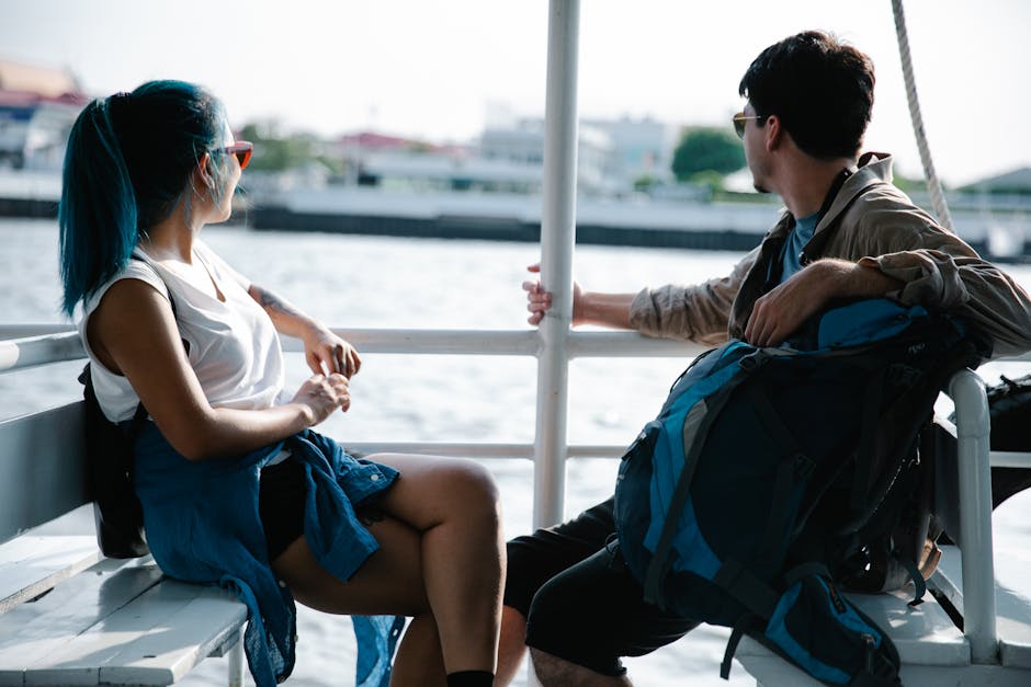 A young couple enjoys a relaxing boat ride with cityscape views in the background, capturing a moment of travel and exploration.