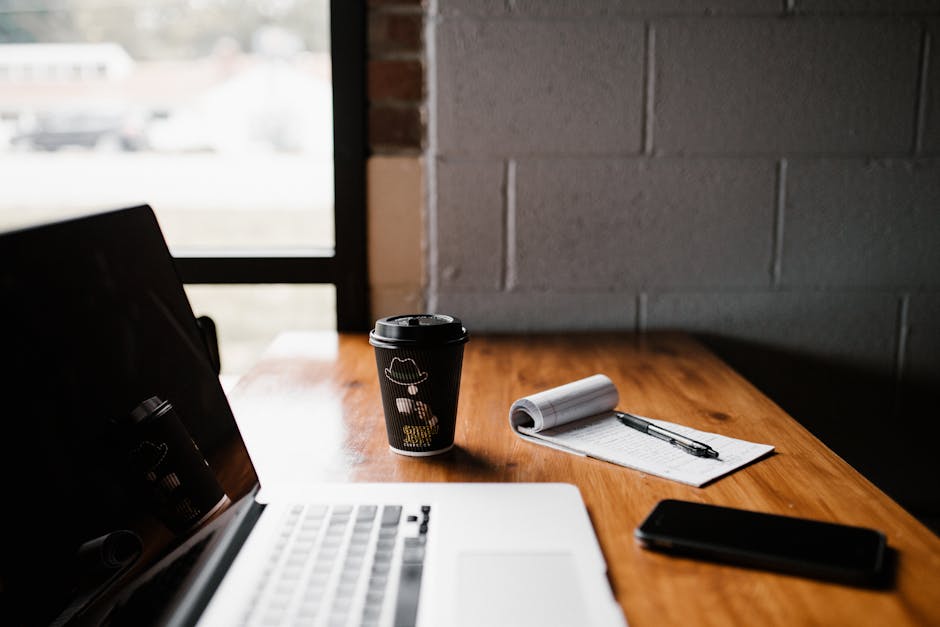 Modern workspace setup with coffee and laptop in Greensboro, NC, highlighting productivity.