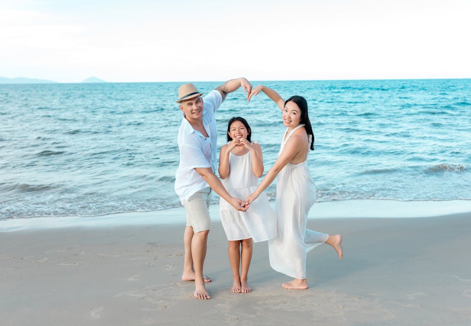 Happy family enjoying a day at the beach in Hội An, making heart shapes with their hands.