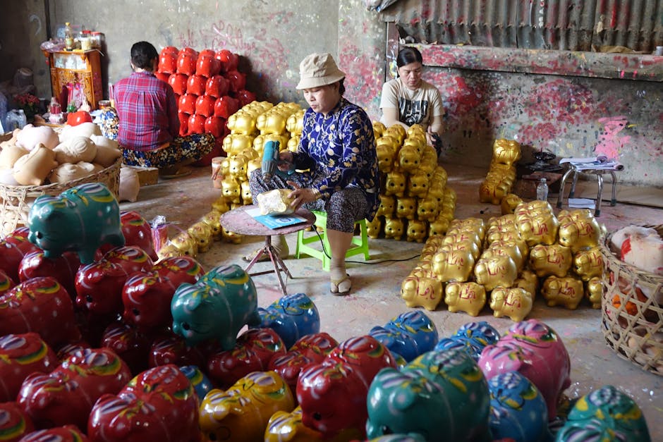 Artisans work in a vibrant workshop painting piggy banks, showcasing traditional craftsmanship.