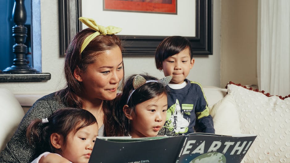 A mother and three children enjoy story time on a cozy couch.