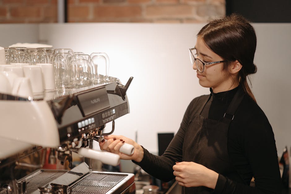 A barista skillfully preparing coffee using a professional espresso machine indoors.