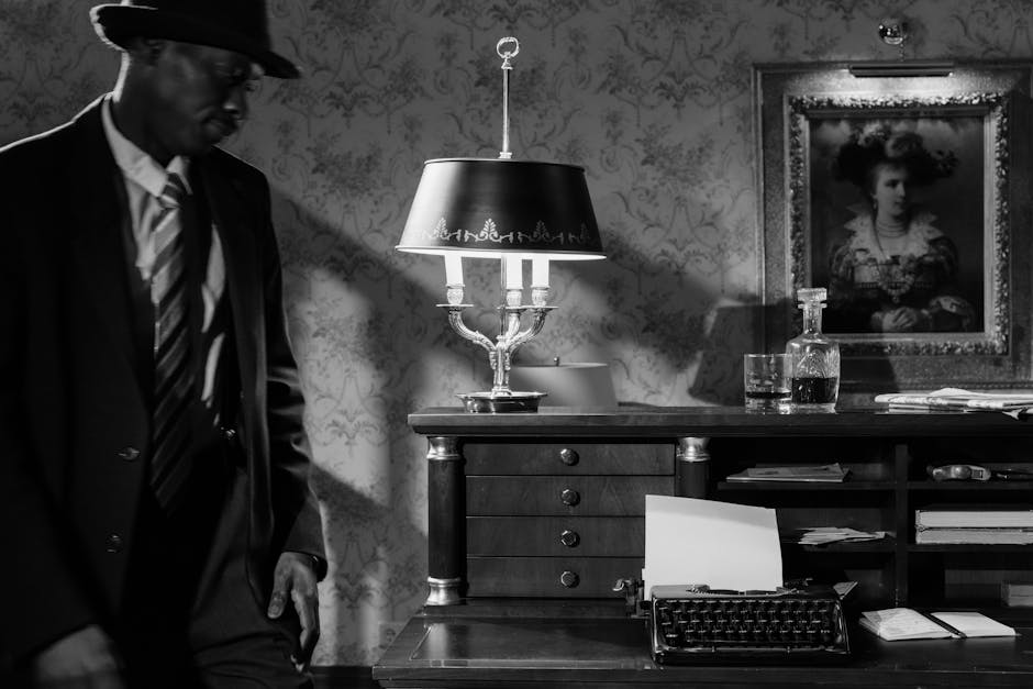 Moody black and white photo of a detective in a vintage office, evoking classic noir cinema.