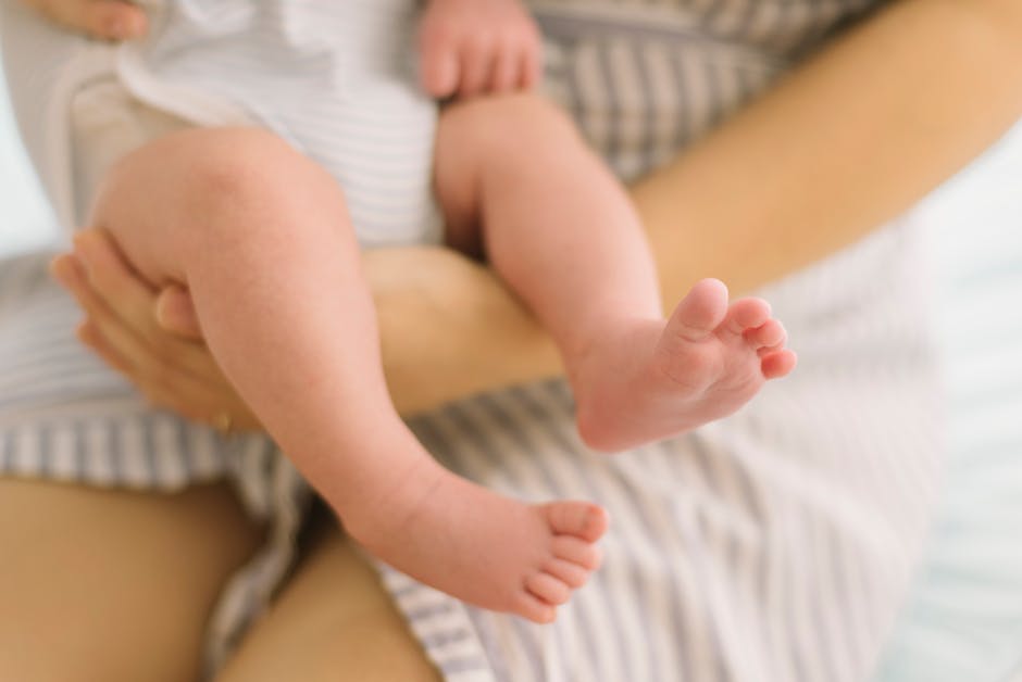 A tender moment of a mother gently holding her baby's feet, showcasing love and care.