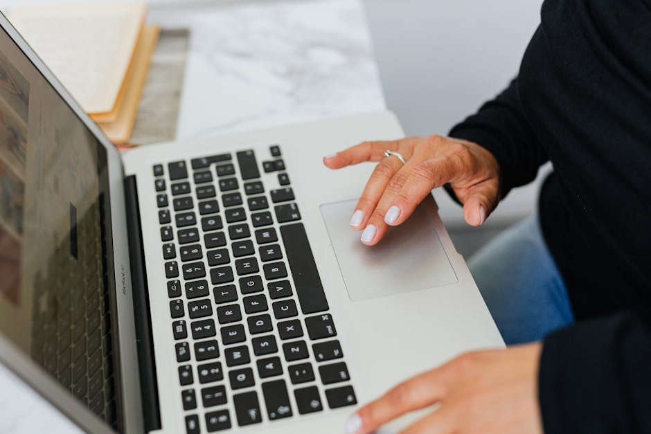 Close-up of hands typing on a laptop, ideal for tech and lifestyle themes.