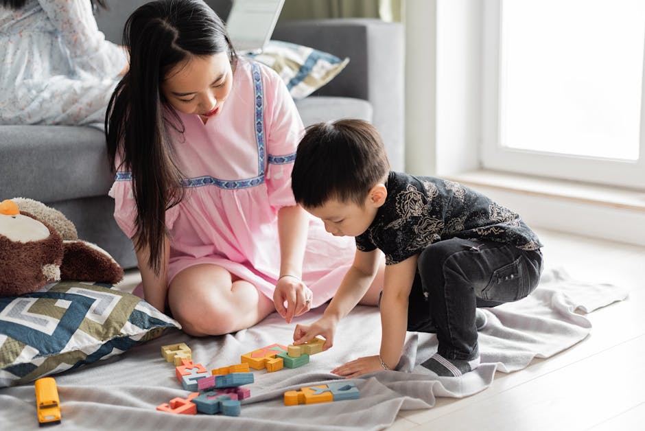 An Asian mother and son enjoy quality time together playing with colorful toys on the floor.