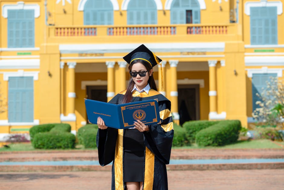 Young graduate woman in academic regalia holding diploma outdoors near building.