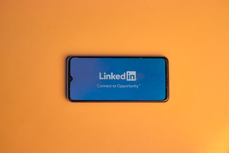 Smartphone showing LinkedIn login on vibrant orange background, symbolizing connectivity.