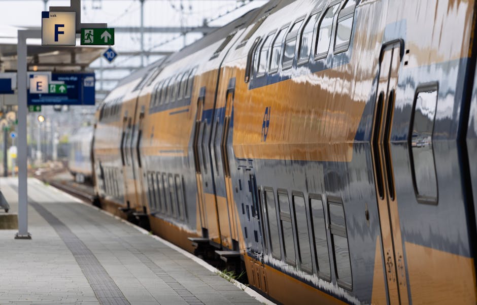 A sleek, yellow and blue train awaits departure at a station platform in the Netherlands.
