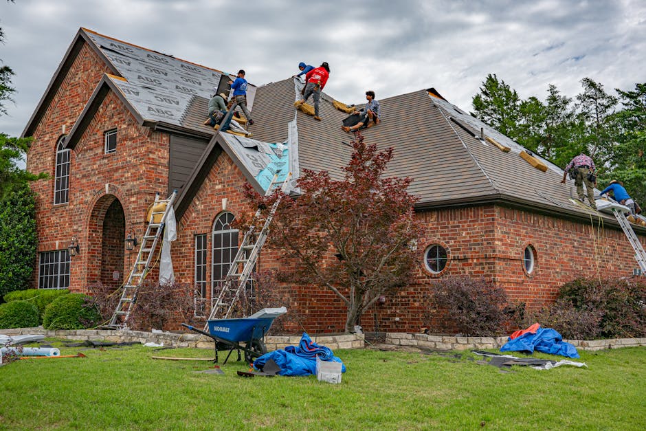 Roofers working on brick home in Allen, Texas, addressing shingles and roofing materials.