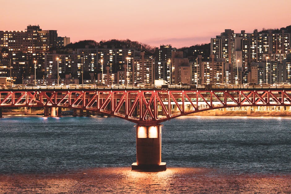 A stunning view of a bridge crossing the Han River in Seoul with city lights illuminating the evening.