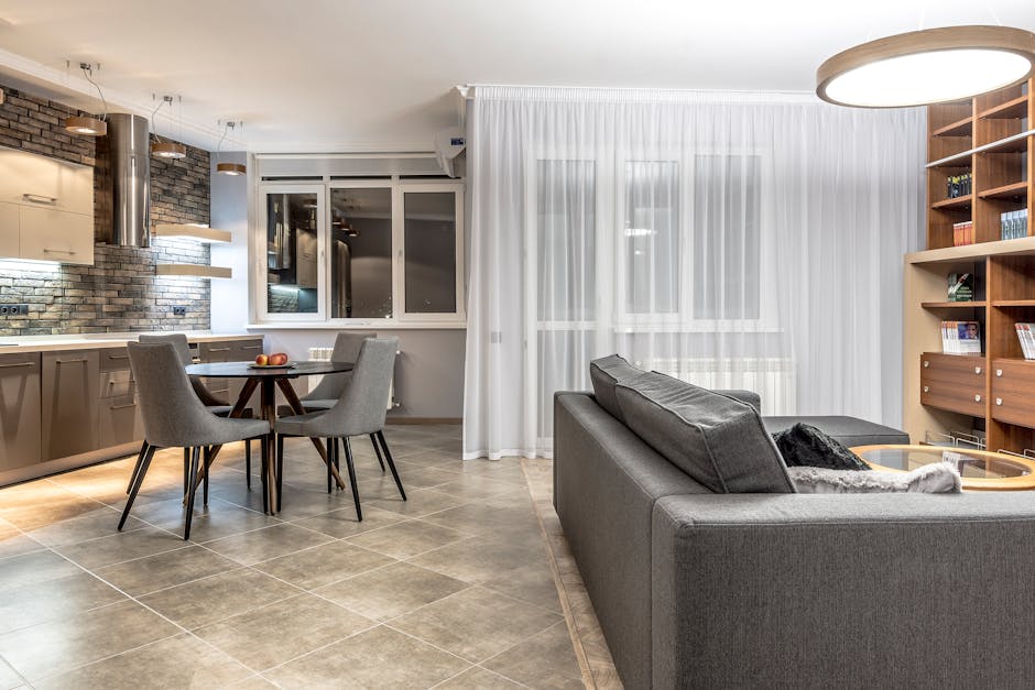 Elegant open-concept living room and kitchen with contemporary decor, emphasizing comfort and style.