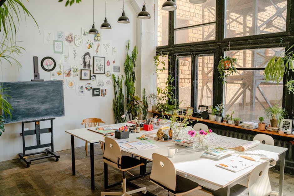 Bright art studio with tables, plants, and various art supplies for creativity and inspiration.