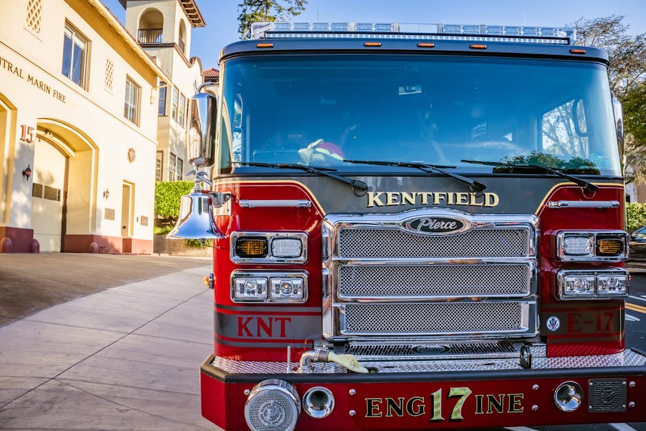 Front view of a red fire truck parked in front of Central Marin Fire Station on a sunny day.