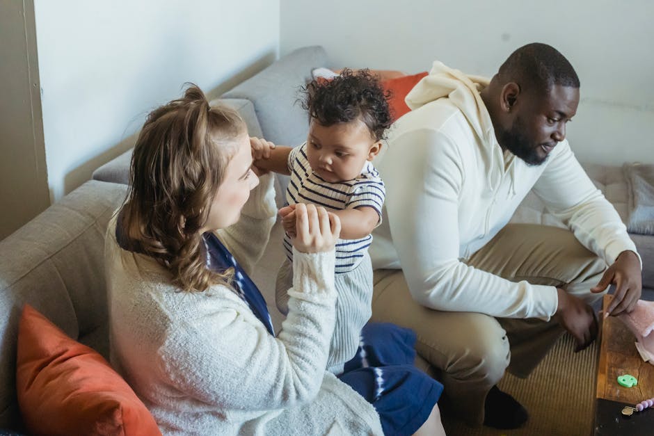 High angle of content mother with cute toddler child interacting on couch near black father in house