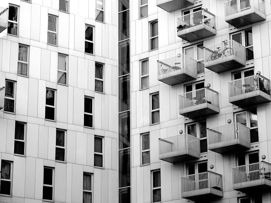 Black and white photo of modern high-rise apartments with multiple balconies.