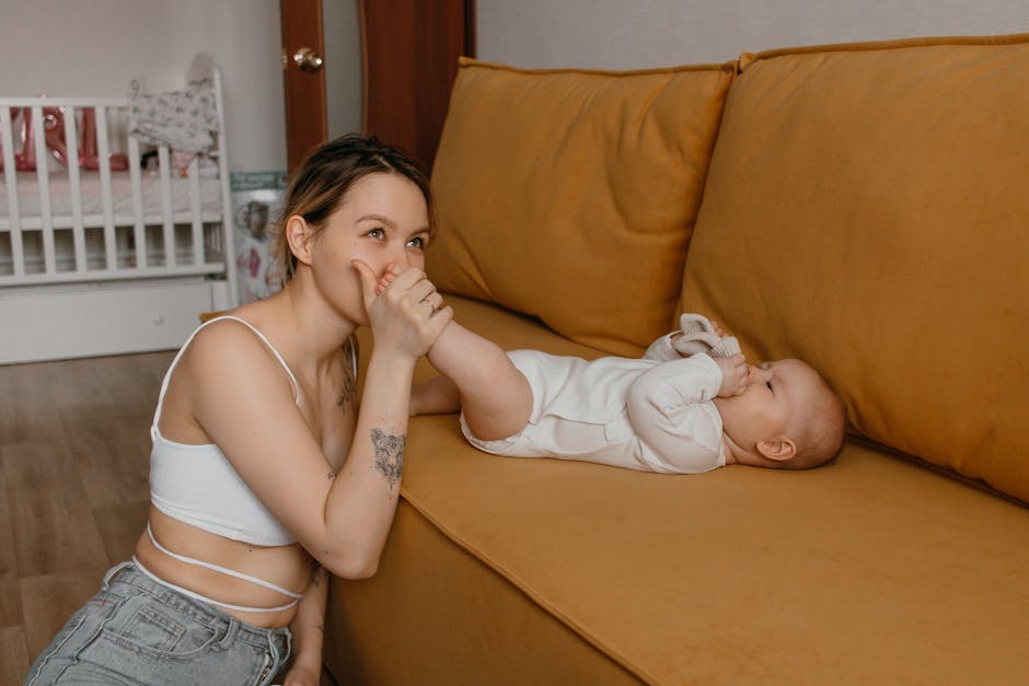 A tender moment between a mother and baby bonding on a cozy couch at home.