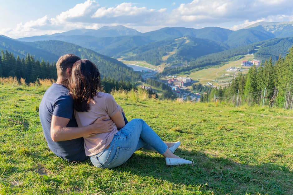 Couple enjoying a scenic view on a mountain, expressing love and togetherness.