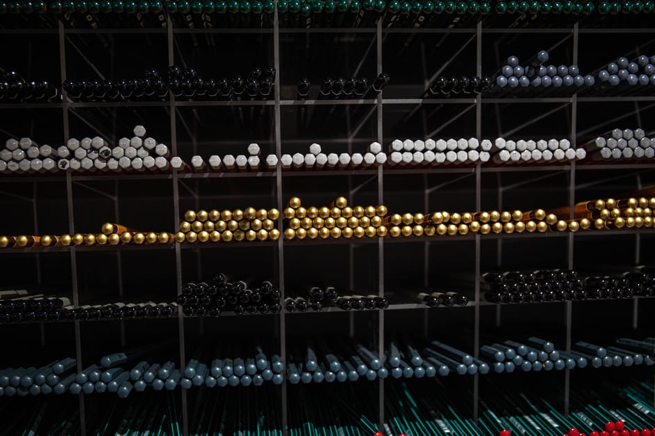 A neatly organized display of colorful pencils arranged on shelves, showcasing a variety of vibrant hues.