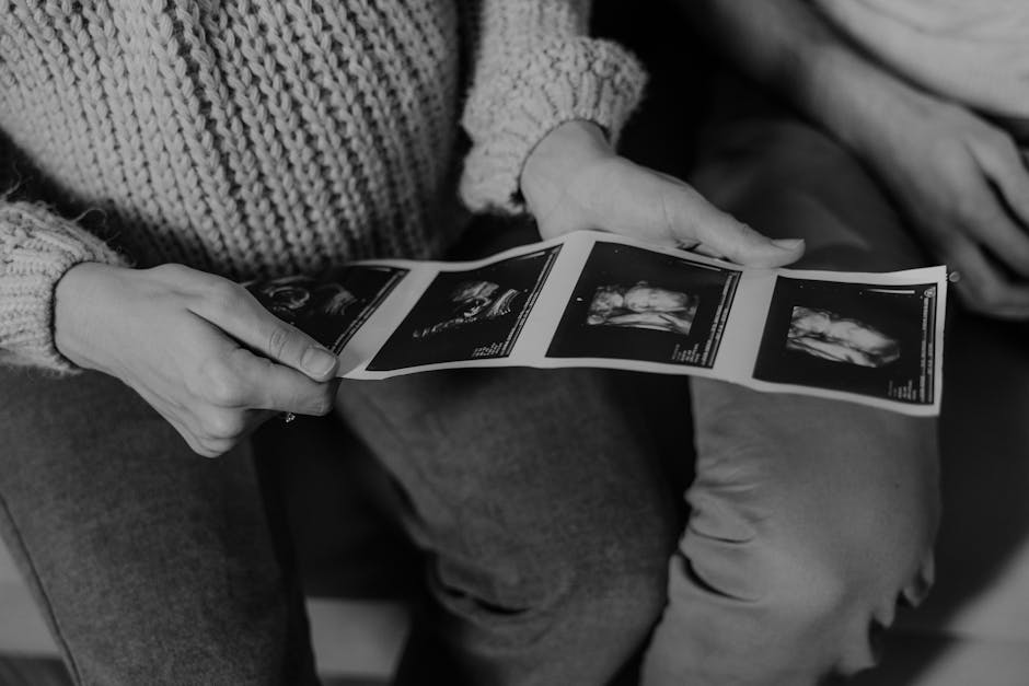 Expectant parents holding ultrasound photos, capturing pregnancy excitement.