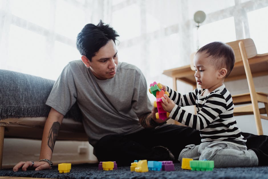 A father and son enjoy quality time indoors, building with colorful blocks together.