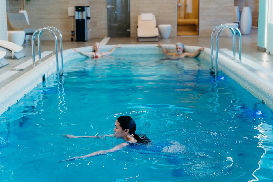 Adults relaxing and swimming in a serene indoor pool setting, perfect for leisure and recreation.