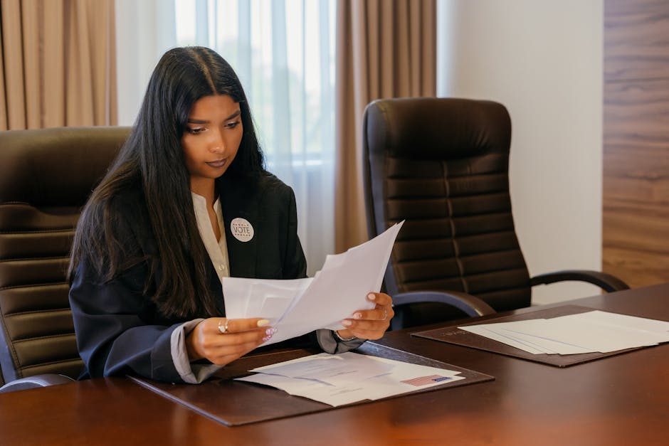 Professional woman in office analyzing important documents with a focus on political responsibilities.