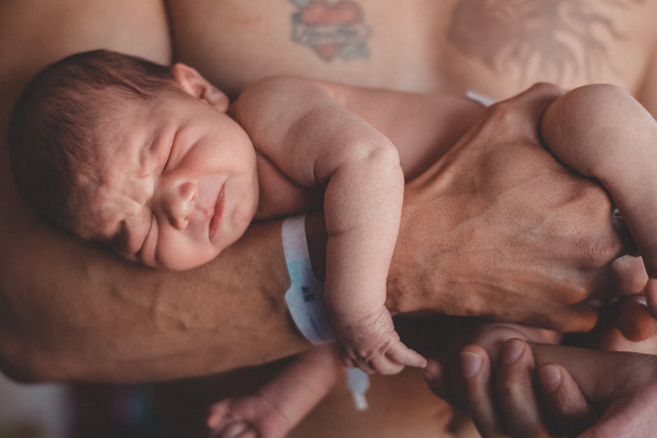 Heartwarming photo of a newborn baby cradled protectively in a father's arms, symbolizing love and care.