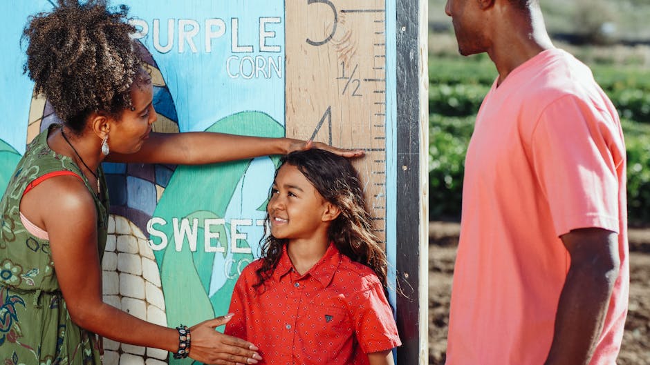 Family enjoys a sunny day measuring child's height at a corn field.