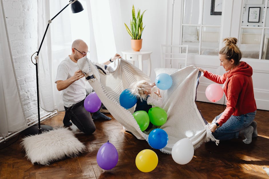 A family enjoying playful moments indoors with balloons and blankets, promoting togetherness and fun.