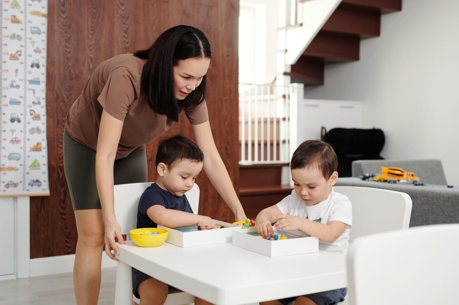 Mother spending quality time playing and learning with her kids indoors.