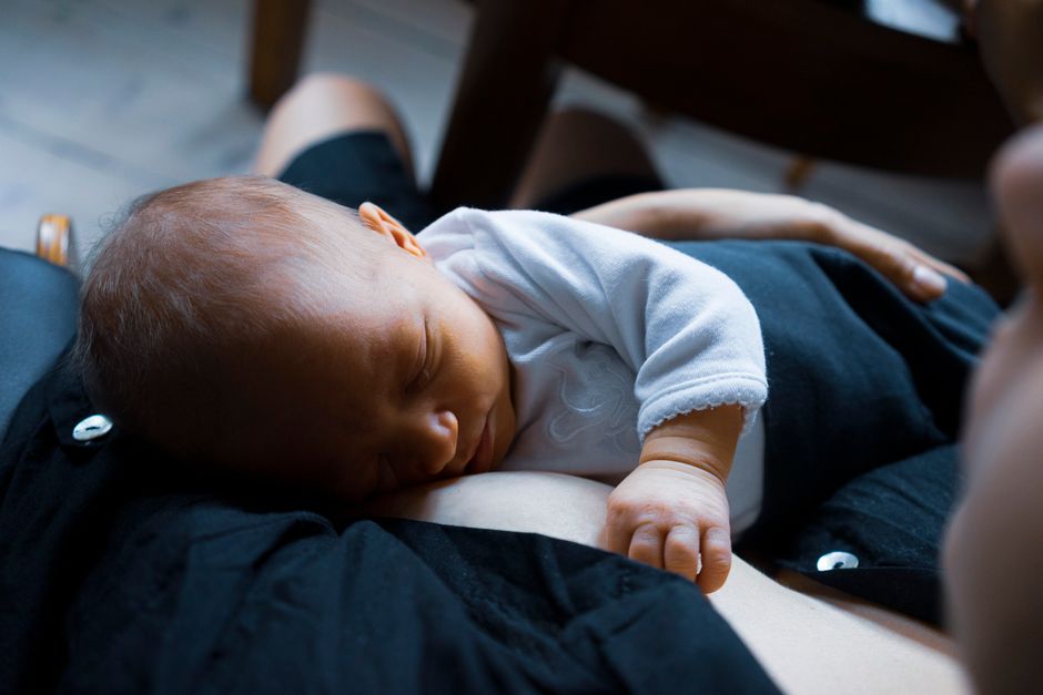 A serene image of a newborn baby peacefully sleeping on their mother's chest, capturing a moment of comfort and love.