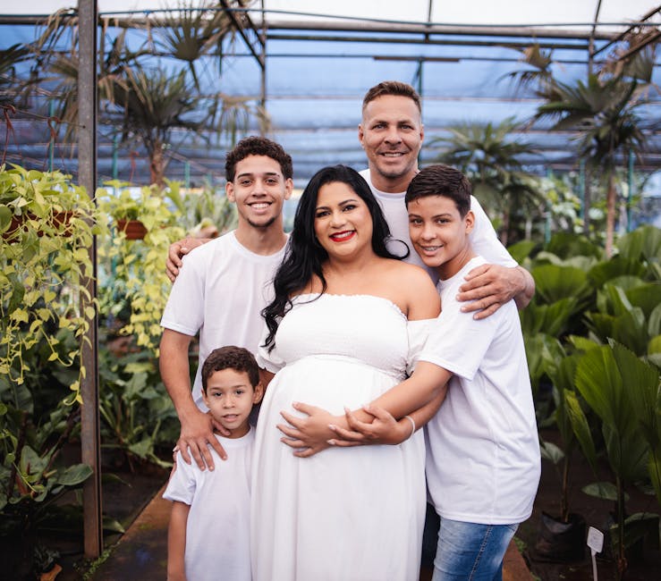 A diverse family portrait of parents and children in a greenhouse, embracing joy and togetherness.