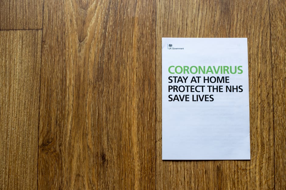 Top view wooden table with sheet of paper with advises regarding behavior during coronavirus pandemic