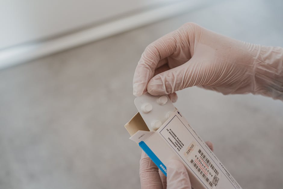 Close-up of hands in gloves handling medication blister pack, ensuring safety and hygiene in healthcare.
