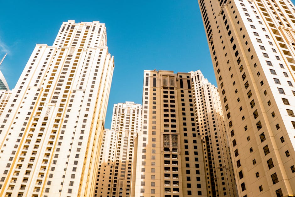 High-rise residential buildings in a modern cityscape contrast with a clear blue sky.