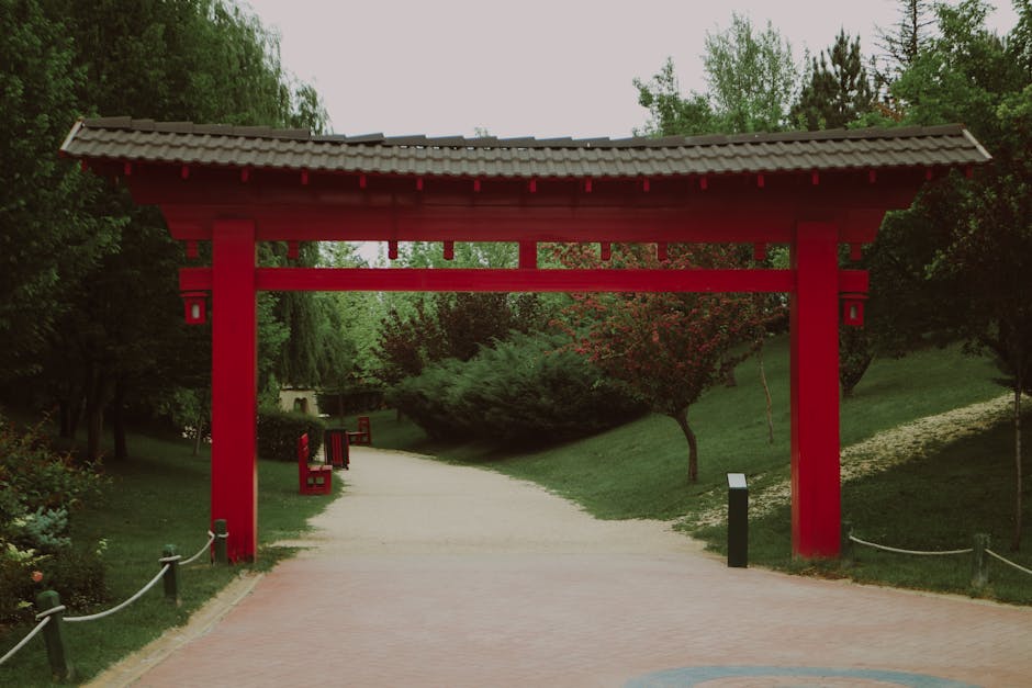 A picturesque torii gate surrounded by lush greenery in a tranquil Japanese garden.