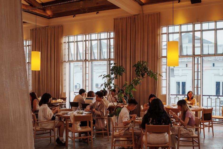 A warm, inviting cafe ambience with people dining in George Town, Malaysia.