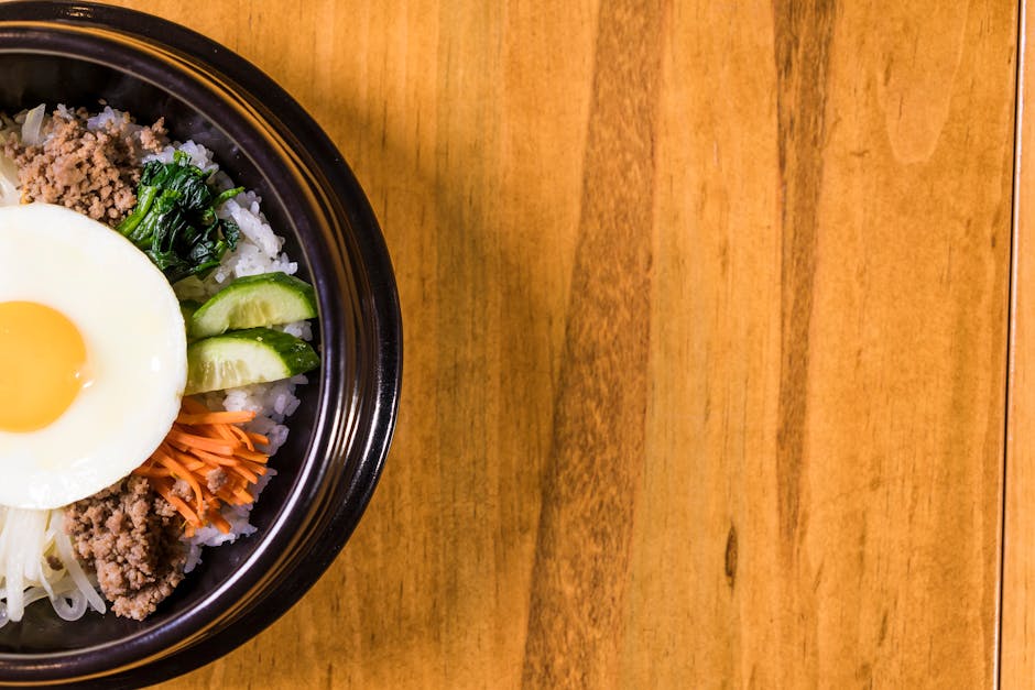 A delicious Korean bibimbap with vibrant vegetables and egg served in a bowl.