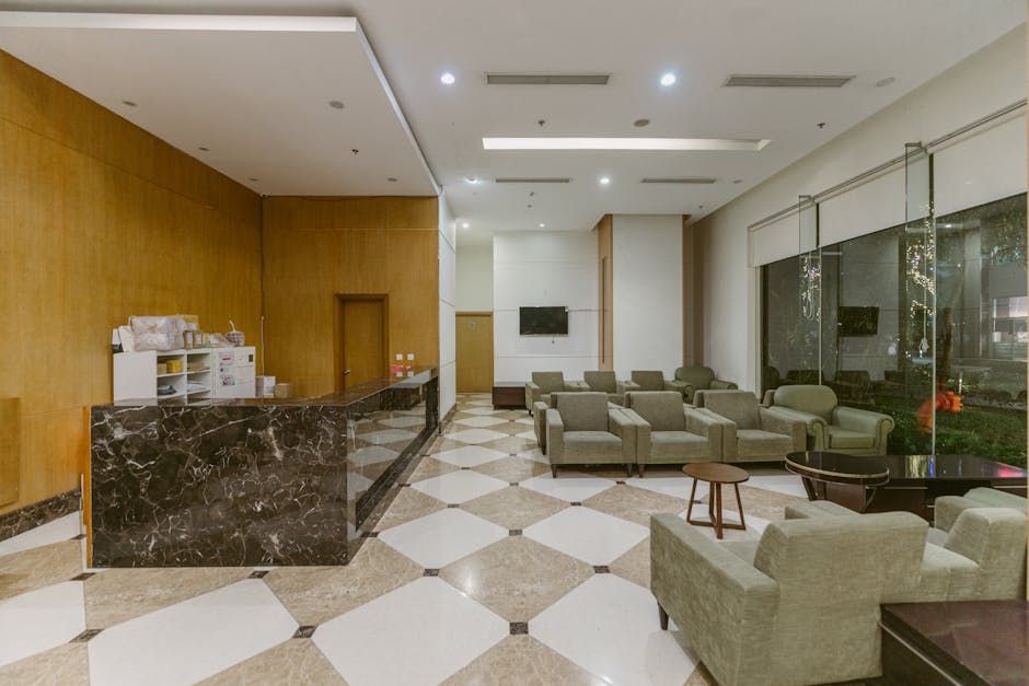 Spacious hotel lobby with marble front desk, modern seating area, and contemporary decor.